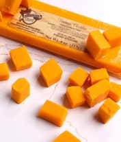 Alternative image 1 for A charcuterie box with two types of cheese, crackers, stone-ground mustard, and a summer sausage.
