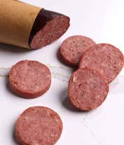 Alternative image 2 for A charcuterie box with two types of cheese, crackers, stone-ground mustard, and a summer sausage.