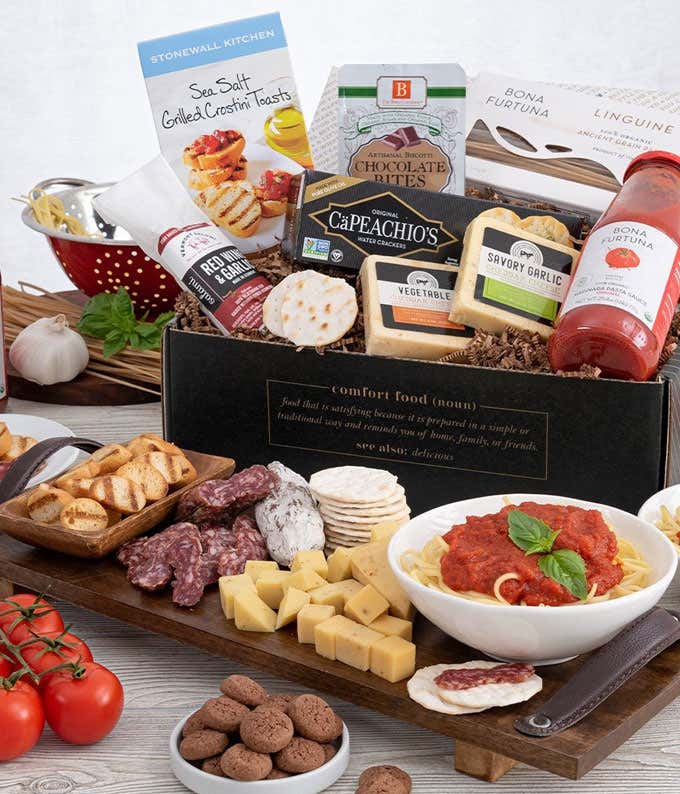 Gift ox with a box of grilled crostini toasta, jar of pasta sauce, blocks of garlic and vegetable cheese, sweet Soppressata, and chocoate bites. In front of the box is a grazing tray with crostini toasts, sliced Soppressata, cubed cheese, water crackers, 