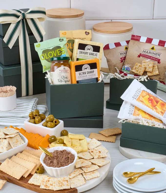 Forest green gift tower with bow, showcasing lemon & rosemary olives, basil & garlic olives, garlic cheese, cheddar cheese, olive oil & sel gris organic flatbread crackers, and Olive Feta Spread, with personalized gift message.