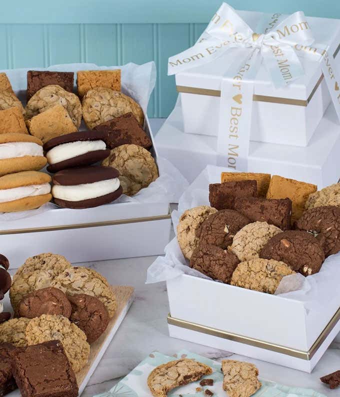 Mothers Day cookie gift tower with white and gold boxes filled with assorted cookies, including sandwich cookies, chocolate chunk, oatmeal, blondies, and brownies, wrapped with a ribbon that reads Best Mom Ever.