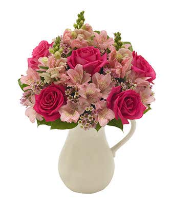 Pink roses and alstroemeria in pitcher vase