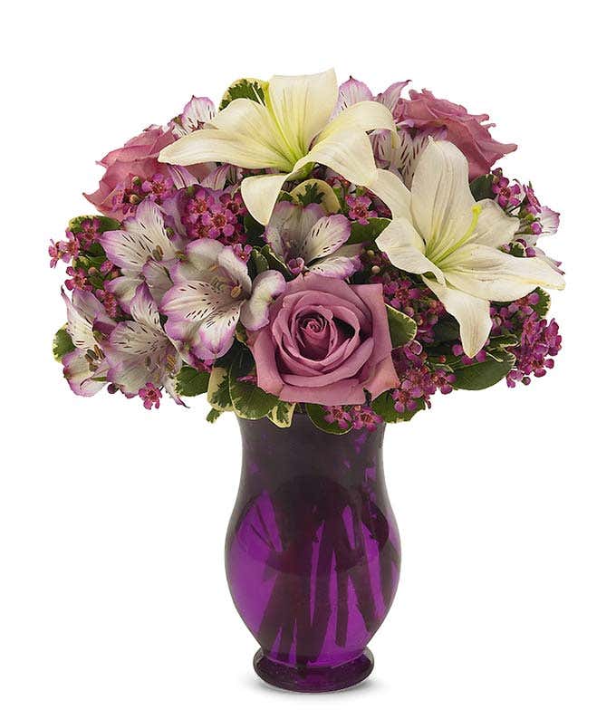 Purple roses, white lilies and purple astroemeria delivered by a florist
