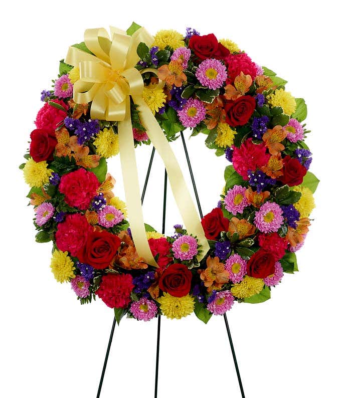 Sympathy wreath of red roses, pink carnations and yellow mums