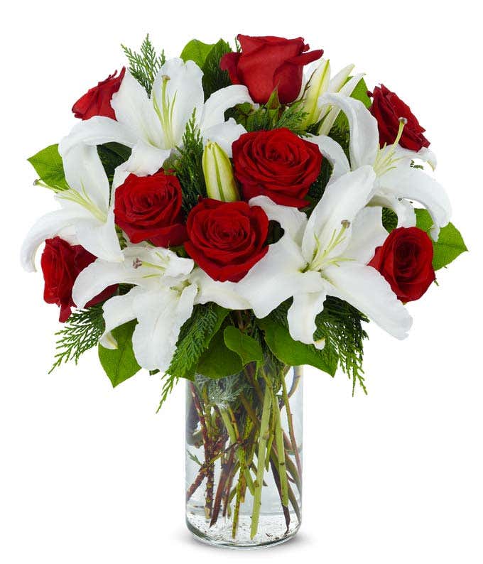 Long stem red roses arranged with white lilies in glass vase