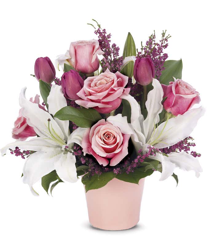 Pink roses, white lilies and colorful tulips in pink cache pot