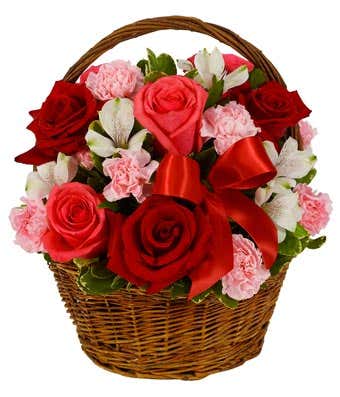 Pink roses, red roses and pink carnations in a woven basket