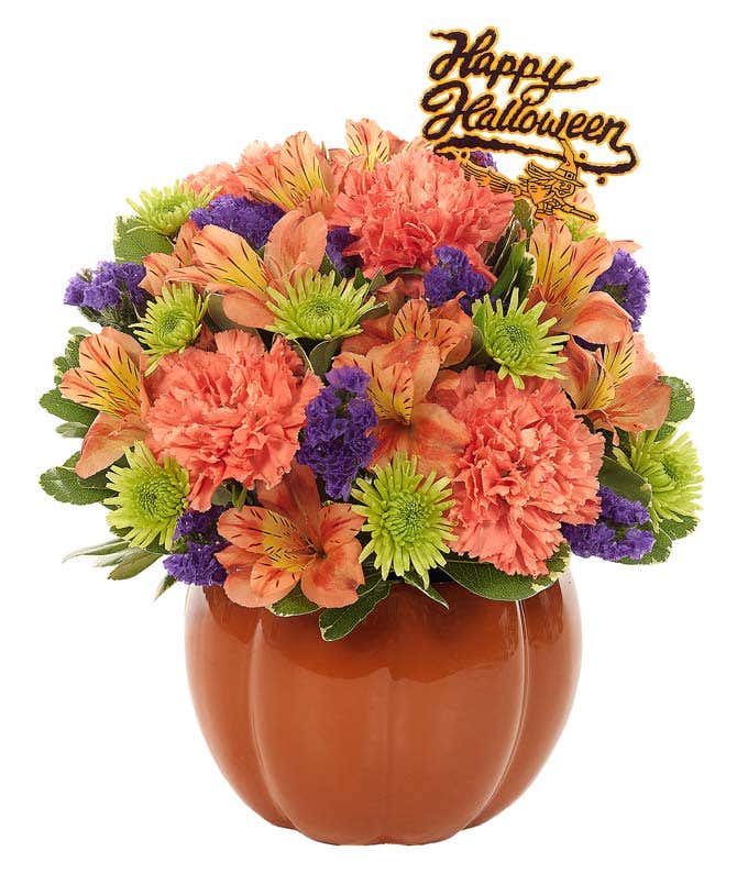 Orange, green and purple flowers in a pumpkin vase