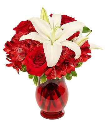 Center lily is surrounded by red roses and red alstroemeria