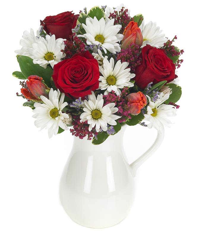 Red roses and white daisies in a reusable pitcher