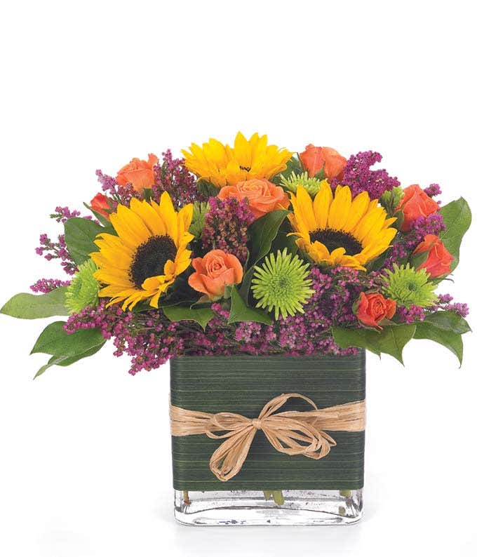 Sunflower and orange roses in square glass vase