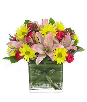 Pink lilies and yellow daisies in a modern vase