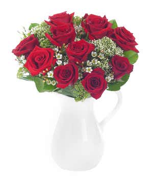 Red roses and white wax flower in reusable pitcher