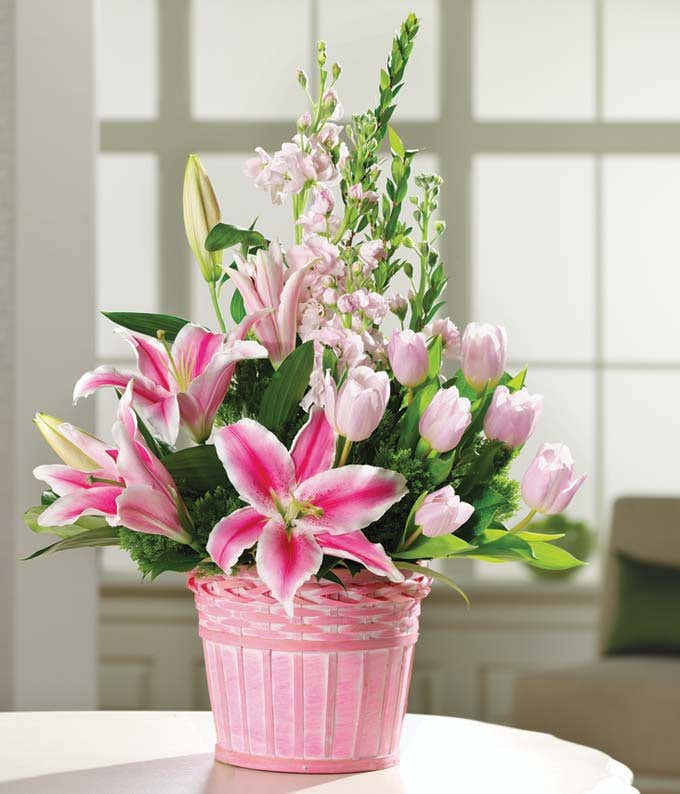 pink tulips and pink lilies in a pink basket
