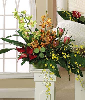 Funeral pedestal arrangement with green, red and orange flowers