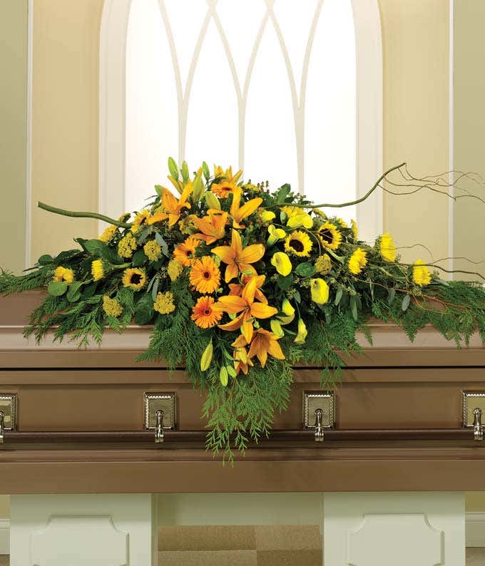 Sunflowers, orange lilies arranged into a casket spray