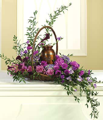 Purple lilies, roses and orchids in sympathy arrangement