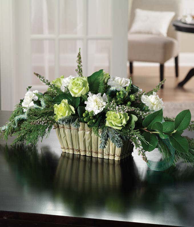 Centerpiece of green roses, hypericum and cream carnations