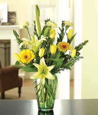 Yellow tulips, gerbera daisies and cream lilies in a bouquet