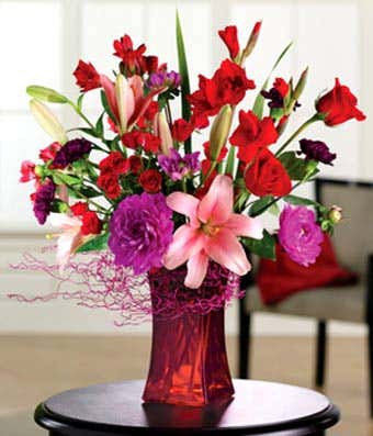 Purple carnations, pink lilies, pink roses and red rose bouquet