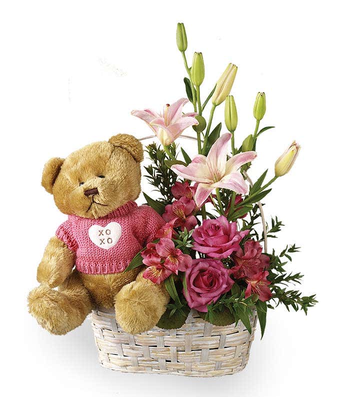 Pink roses and lilies with teddy bear in basket
