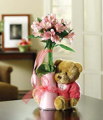 teddy bear with pink flowers in a bud vase