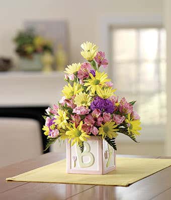 Pink daisies, pink alstroemeria in new baby girl vase