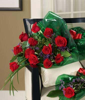 One dozen long stem red roses wrapped with a bow