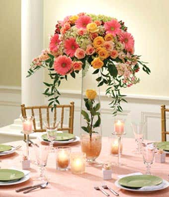 Pink gerbera daiseis and orange roses in a floral centerpiece