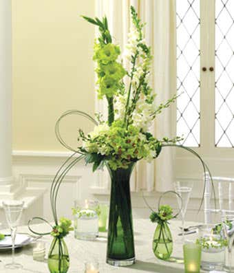 Green & white roses and orchids in a centerpiece