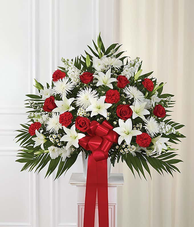 Sympathy flowers with red roses and white flowers in basket