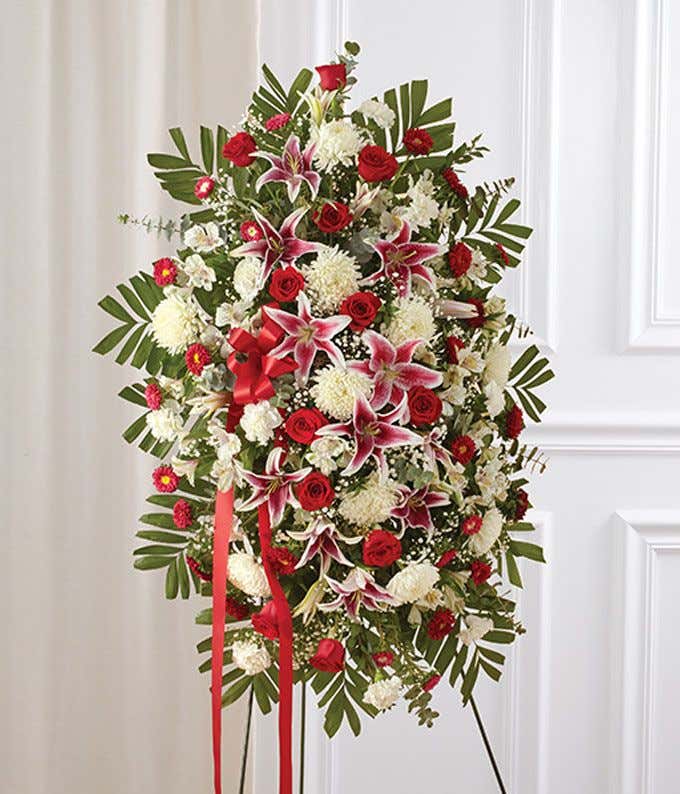 Red roses, gerbera daisies and spray roses in a standing spray