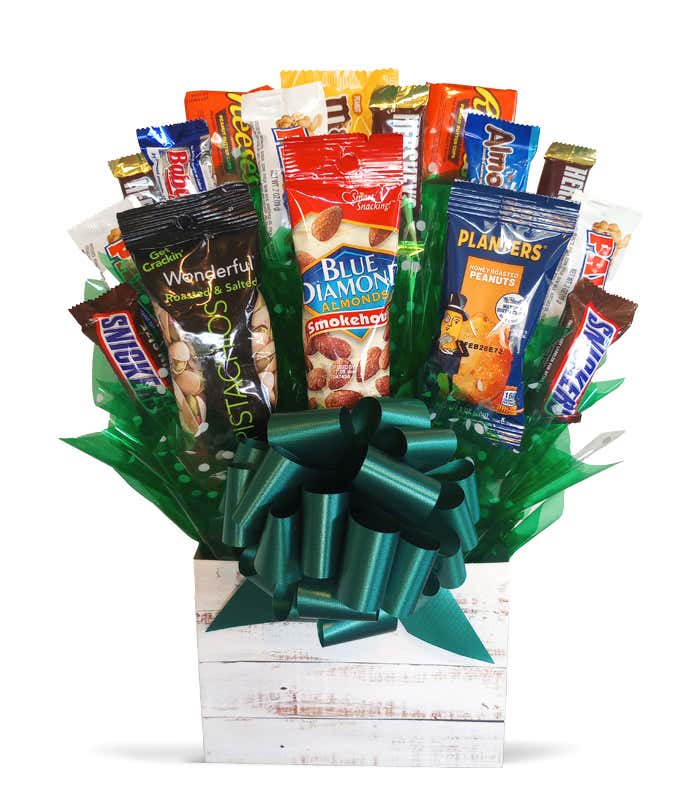Candy bouquet featuring 13 fun-size candy bars with nuts and 3 assorted nut packages arranged in a white wooden box with green tissue paper and a dark green bow.