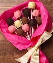 Alternative image 2 for A bouquet of Belgian chocolate roses in milk, dark, and white chocolate, wrapped in pink tissue paper and tied with a cream ribbon, accompanied by a bottle of red wine and card reading 