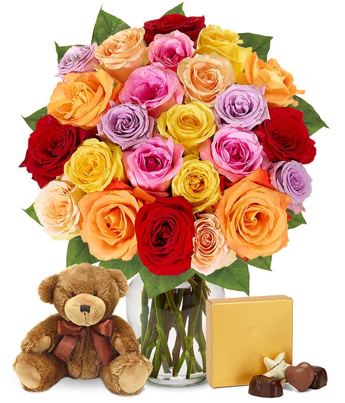 I'm sorry gift set featuring two dozen vibrant rainbow roses, a cuddly teddy bear, and a box of chocolates, with optional glass vase and personalized message. A sincere gesture to seek forgiveness with warmth and sweetness.