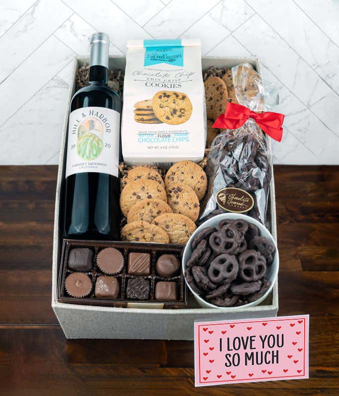 a gift box full of decadent treats with an I Love You message card.  Contents include: a bottle of California Pinot Noir, a bag of milk chocolate pretzel, a box of mini chocolate chip cookies, and a 4-ounce box of assorted chocolates.