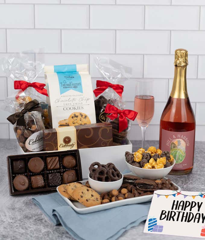 A gift set featuring a bottle of California Sparkling Wine paired with chocolate-covered pretzels, mini cookies, caramel popcorn, chocolate peanut butter buckeyes, 6 chocolate-covered Oreos, a box of assorted chocolates, and Birthday card.