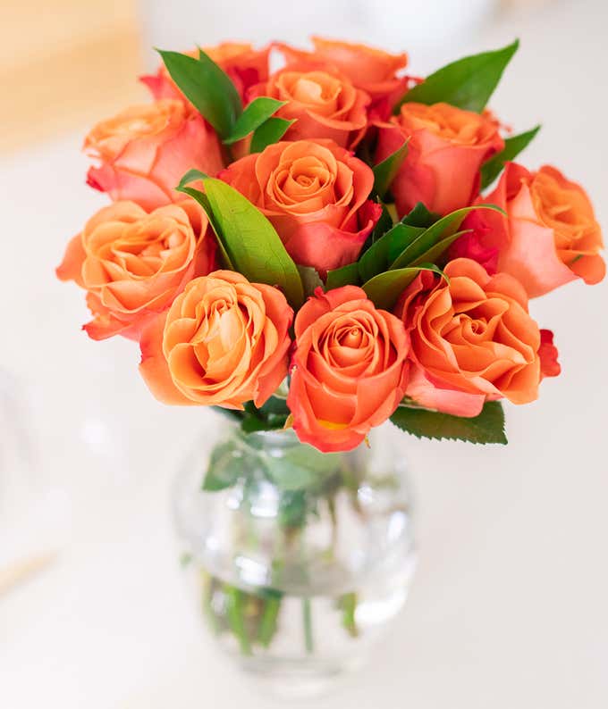 One Dozen Orange Roses in Clear Glass Vase