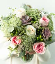 Alternative image 4 for A floral arrangement featuring white roses, pink roses, succulents, white stock, hypericum berries, Queen Anne's lace, white waxflower, and seeded eucalyptus, with an optional glass vase.