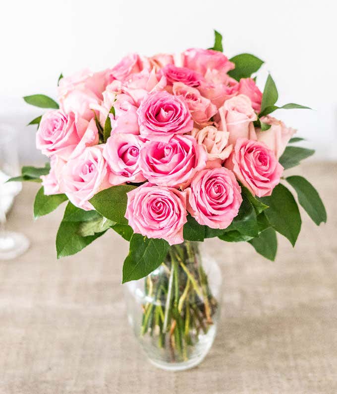 Two Dozen Light Pink Long Stem Roses in a Clear Glass Vase