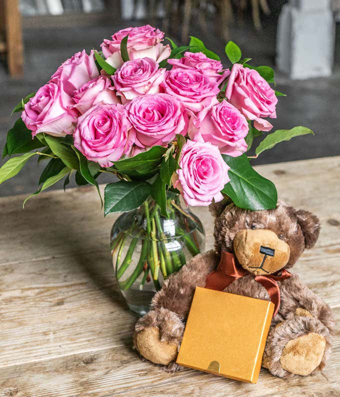 One Dozen Pink Roses with a Clear Glass Vase, Chocolates, & Teddy Bear
