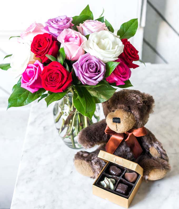 One Dozen Red, Pink, Purple & White Roses with a Clear Glass Vase, Chocolates, & Teddy Bear