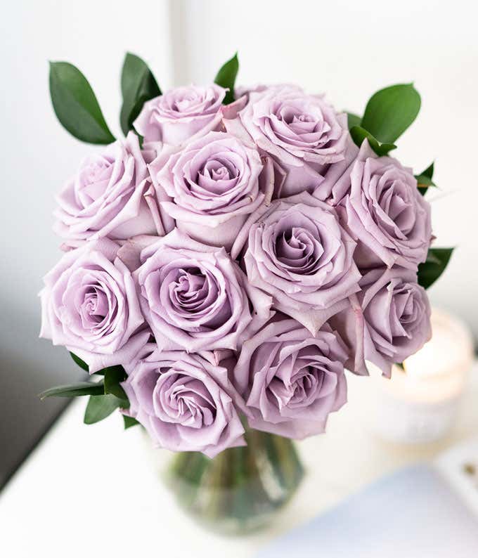 One Dozen Long Stem Purple Roses in a Clear Glass Vase