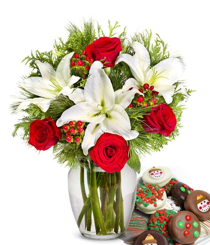 Bouquet of red roses, white lilies, red berries, and  seasonal greens, in a clear vase with one dozen chocolate dipped oreos with candy and snowman toppings