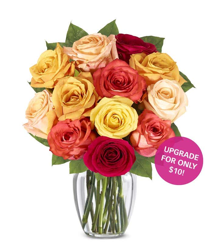 A stunning floral arrangement featuring orange roses, red roses, and yellow roses, optionally presented in a glass vase.