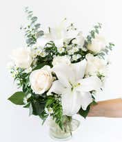 Alternative image 2 for An elegant floral arrangement featuring white roses, white lilies, white asters, and eucalyptus, optionally displayed in a glass vase.