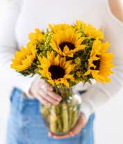Alternative image 1 for Bouquet of vibrant sunflowers arranged in a clear glass vase.