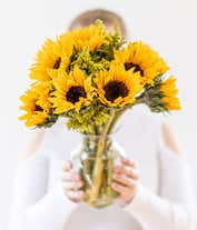 Alternative image 2 for Bouquet of vibrant sunflowers arranged in a clear glass vase.