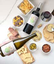 Alternative image 1 for An abundant gift box filled with two bottles of California wine - red & white, assorted crackers, three cheeses, summer sausage, and snacks to make an amazing charcuterie spread. 