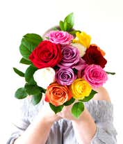 Alternative image 3 for A stunning arrangement of one dozen rainbow roses, beautifully presented in a glass vase. This colorful display features roses in a variety of vibrant hues, creating a striking and eye-catching centerpiece.